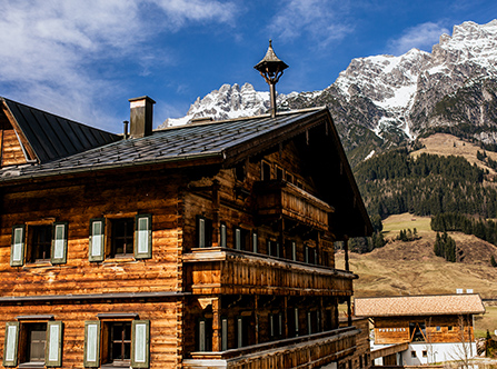 Traditionelles Holzhaus und Berge in Leogang